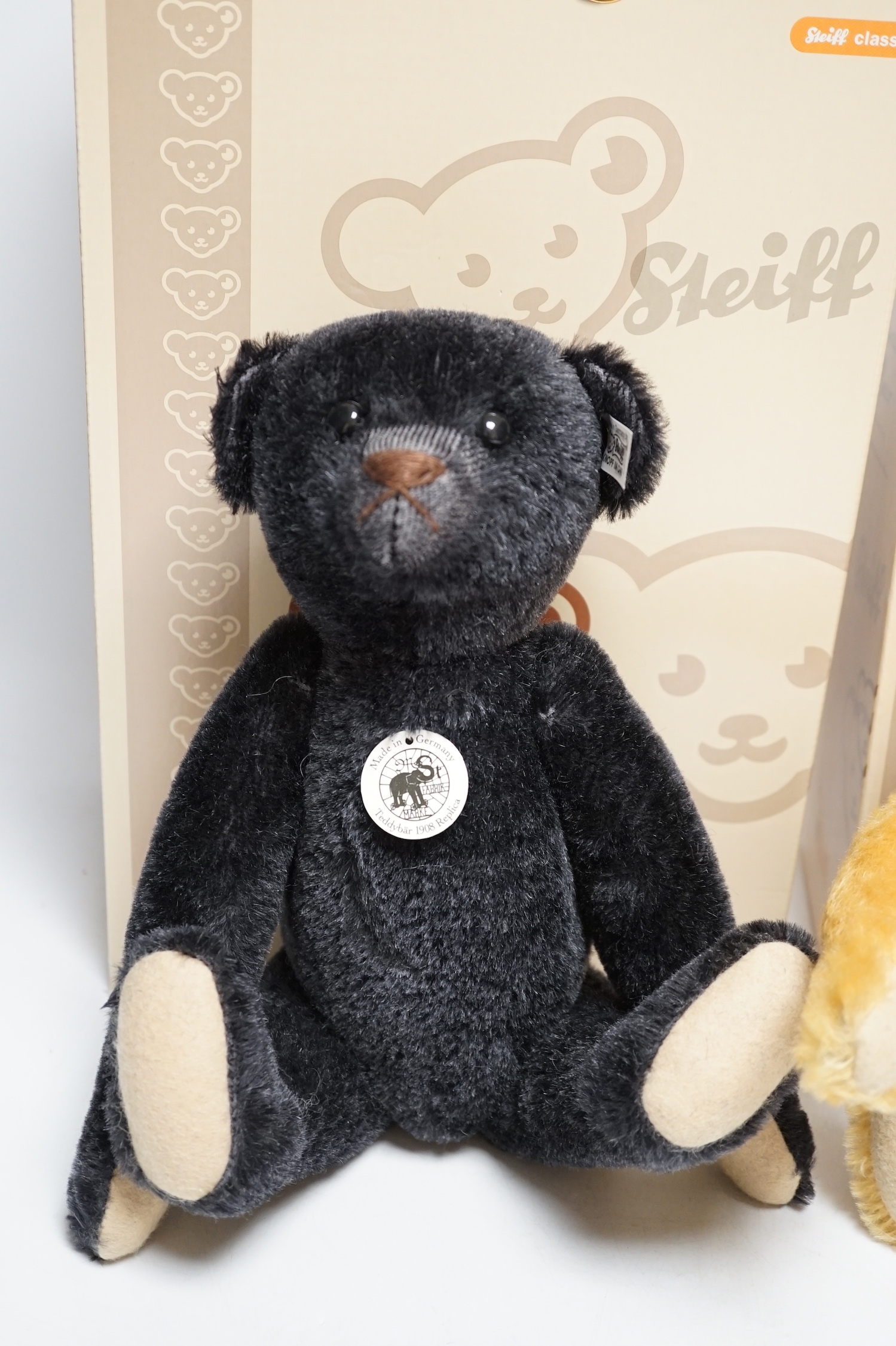 A blond Steiff somersaulting Teddy bear and a Steiff replica 1908 black Teddy bear, each boxed with certificate